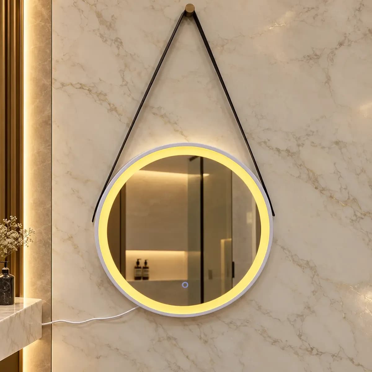 Round mirror hanging from a triangular dark strap, depicted with a warm-looking light ring.