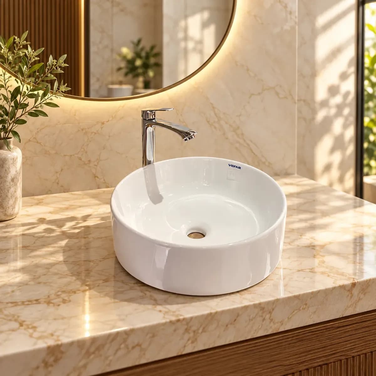 White round countertop-style basin shown with a tall reflective tap; the tap and scene items are not confirmed inclusions.
